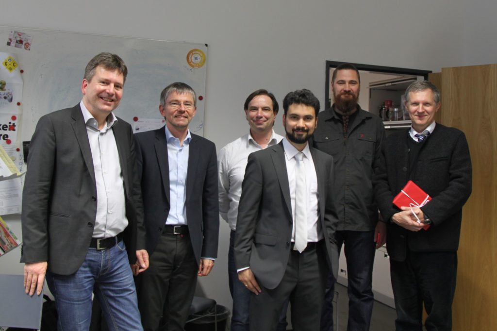 picture of six persons standing: in the middle R. Rosales bettween his thesis experts smiling
