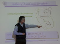 Prof. Michael Mendler pointing at his presentation slide on the wall