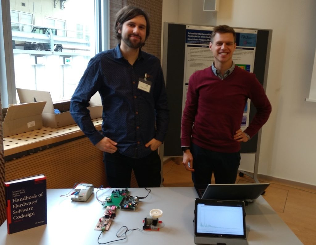 von links stehen Andreas Becher und Franz-Josef Streit vor ihrer auf dem Tisch präsentierten Schaeffler Hardware Box stehend