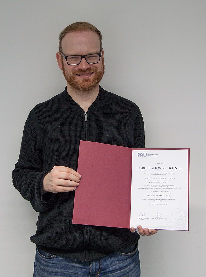 Daniel Ziener proudly showing his habilitation certificate