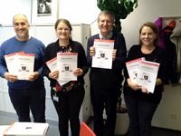 Four persons with a printed proposal in their hands