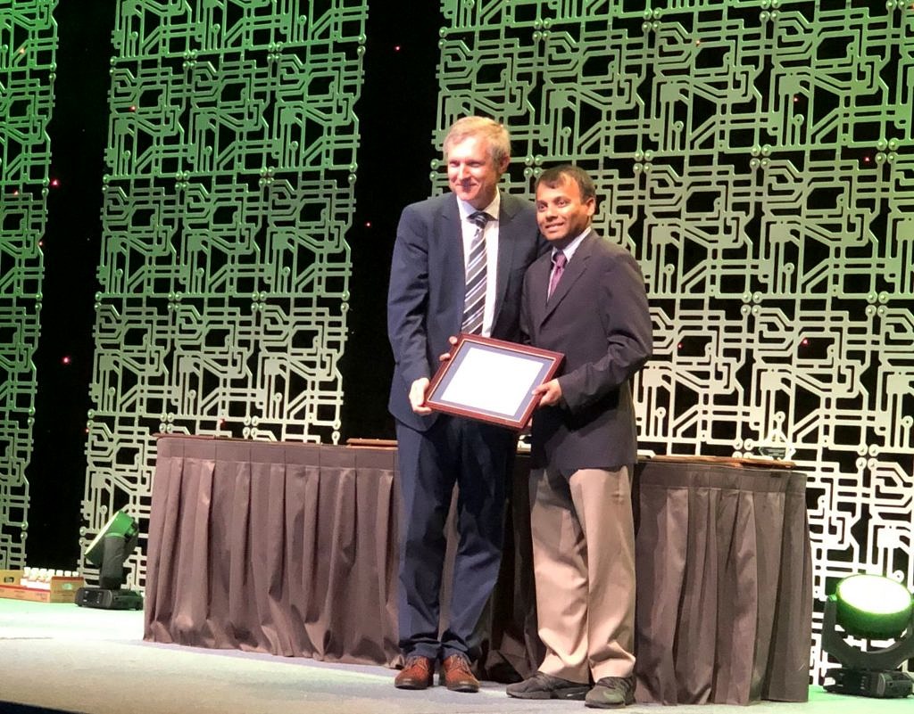 Prof. Teich standing on podium receiving his certificate