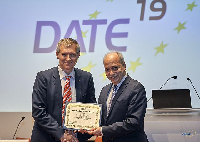 from the left: Prof. J. Teich, FAU, Dr. Y. Zorian, Synopsys shaking hands and holding the award certificate; Copyright: