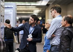 T. Schwarzer showing his poster to interested visitors of exhibition; Copyright: DATE 2019/copyright: Cruz Garcia