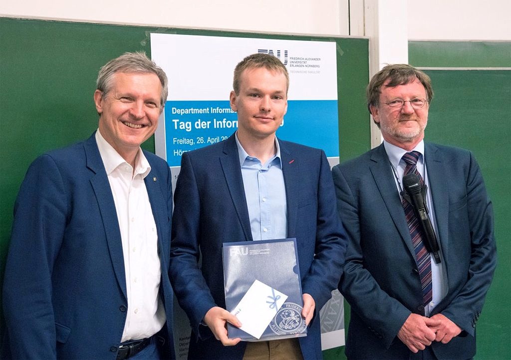 from the left: Prof. J. Teich, F. Wolff, (holding his award in hands) Prof. U. Rüde standing and smiling