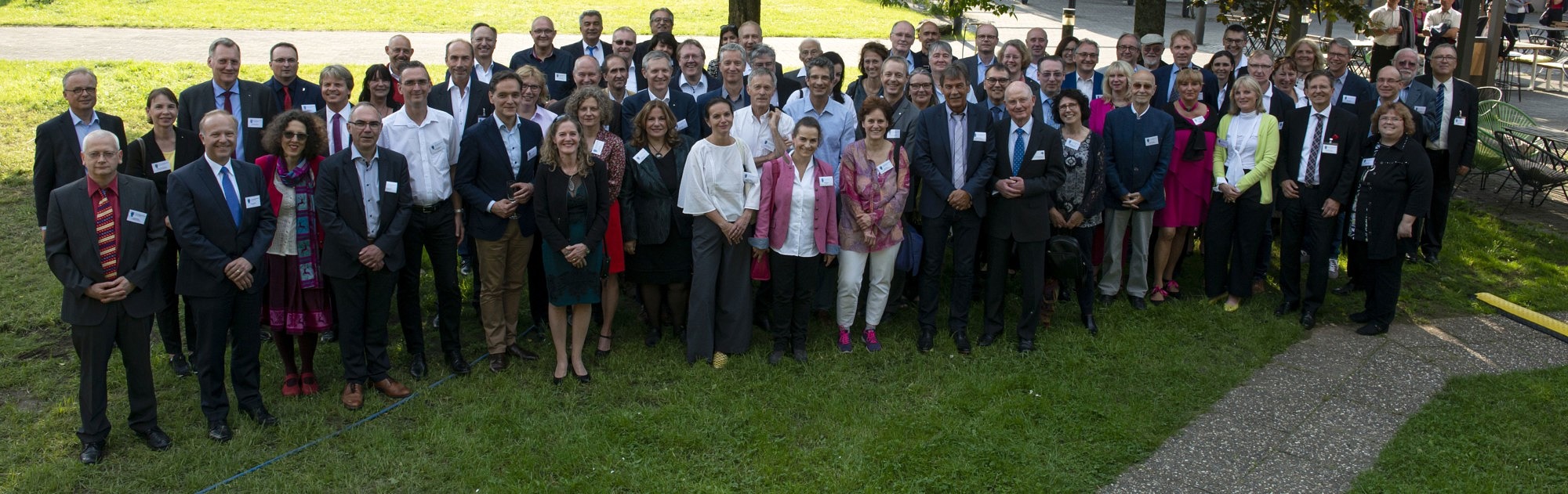 a group of about 60 persons standing on the lawntand