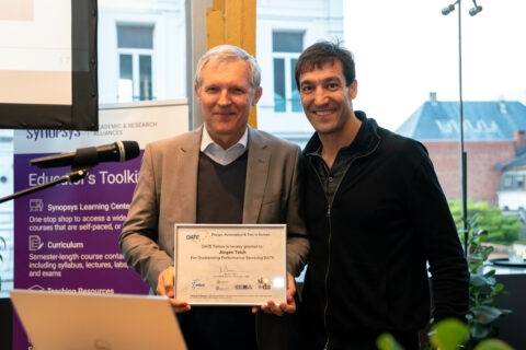 Two men standing beside each other, One is holding an award