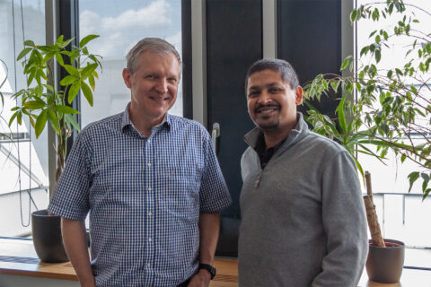 Two men standing in front of windows