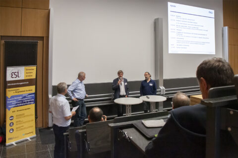 four people hold the panel discussion in front of audience