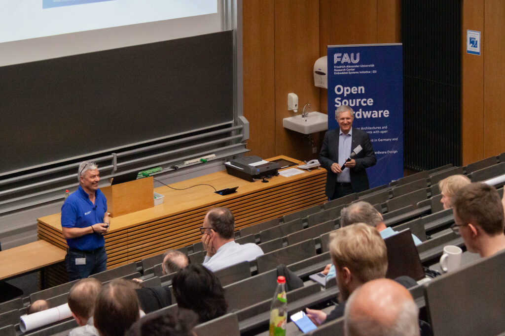Two men give a lecture in front of many people