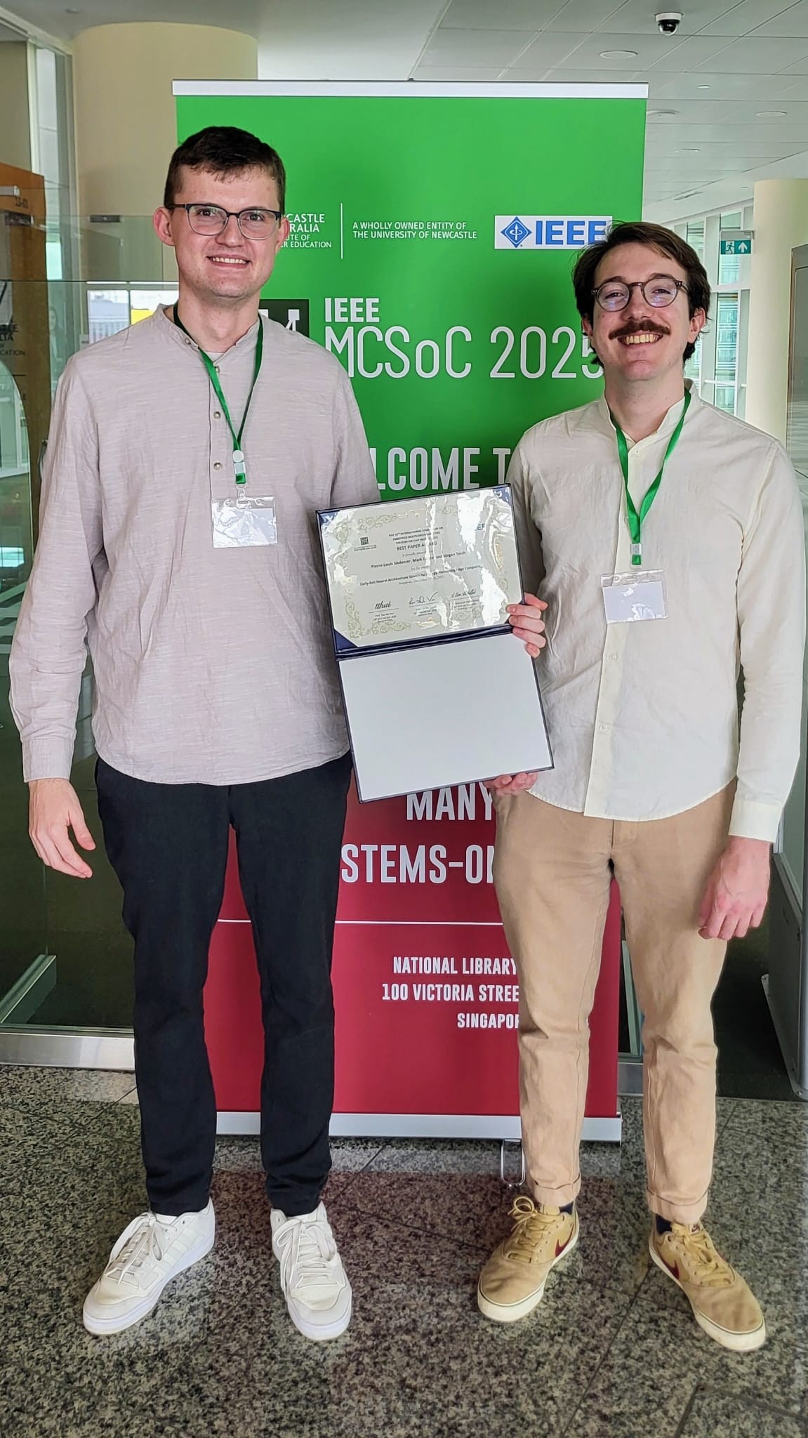 Two persons holding a certificate